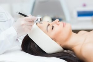 close-up view of a woman's head receiving diamond microdermabrasion treatment.